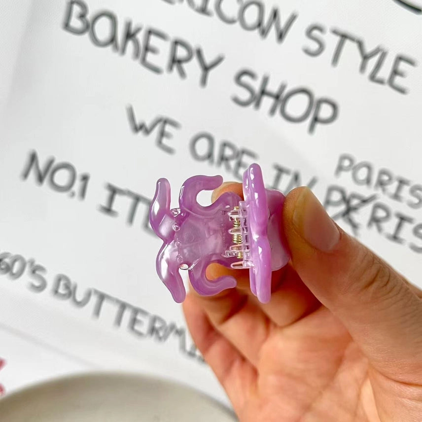 Hand holding a purple silicone baby bottle cover with text in the background