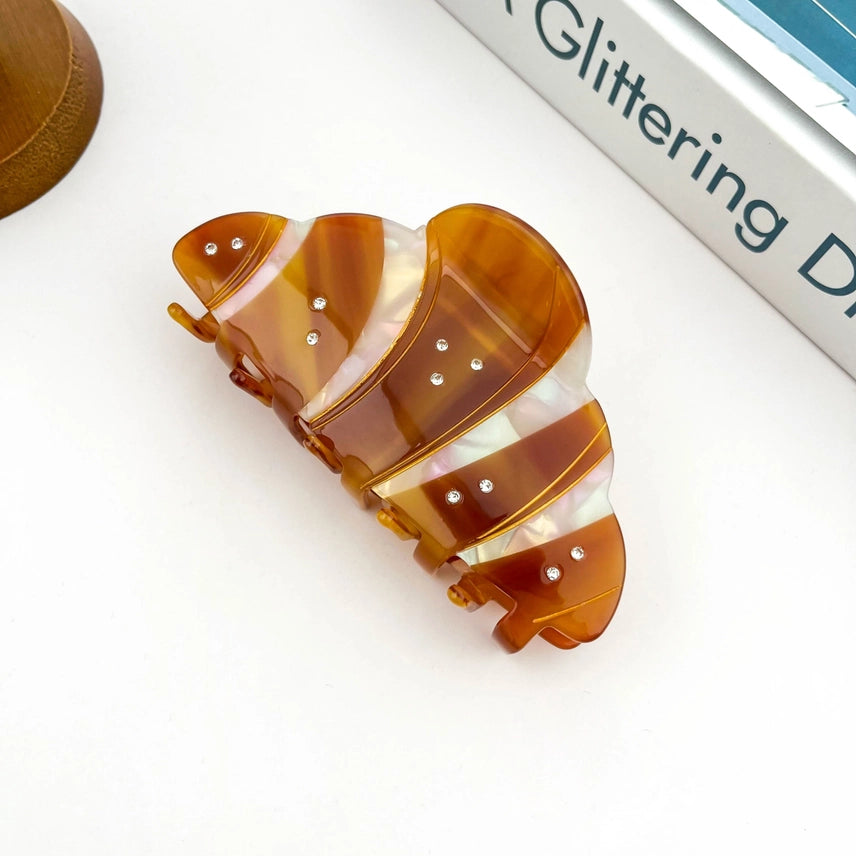 Decorative hair clip with brown and white striped design on a white background