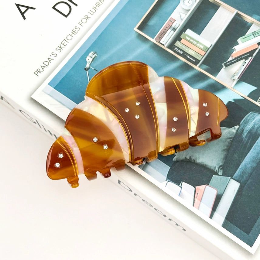 Brown and pink resin hair clip on a magazine