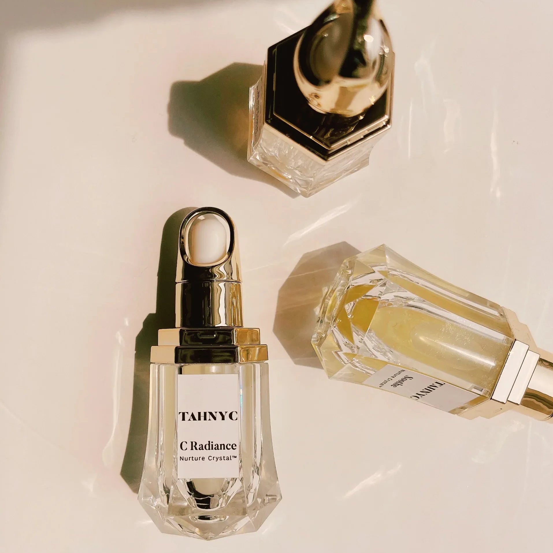 Three perfume bottles with gold caps on a light background