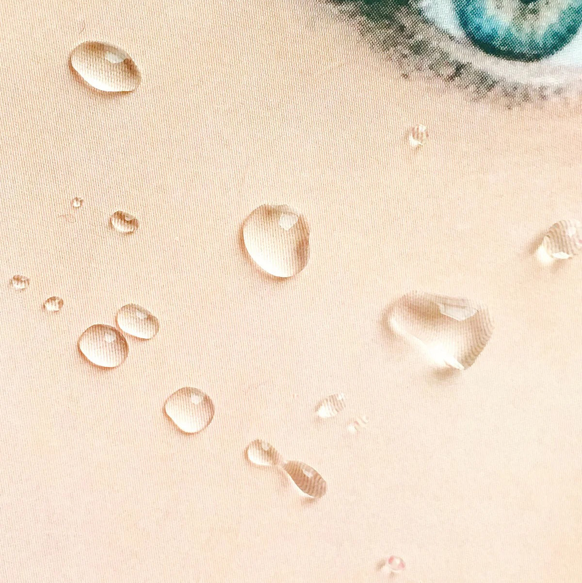 Close-up of water droplets on a person's skin with a blurred eye in the background.