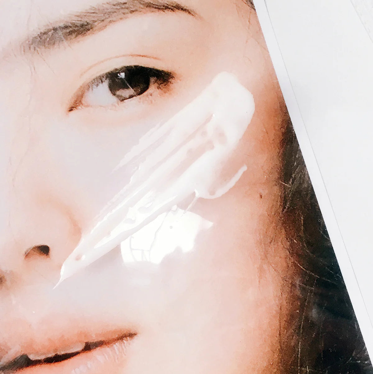 Close-up of a person applying cream to their face with a brush.