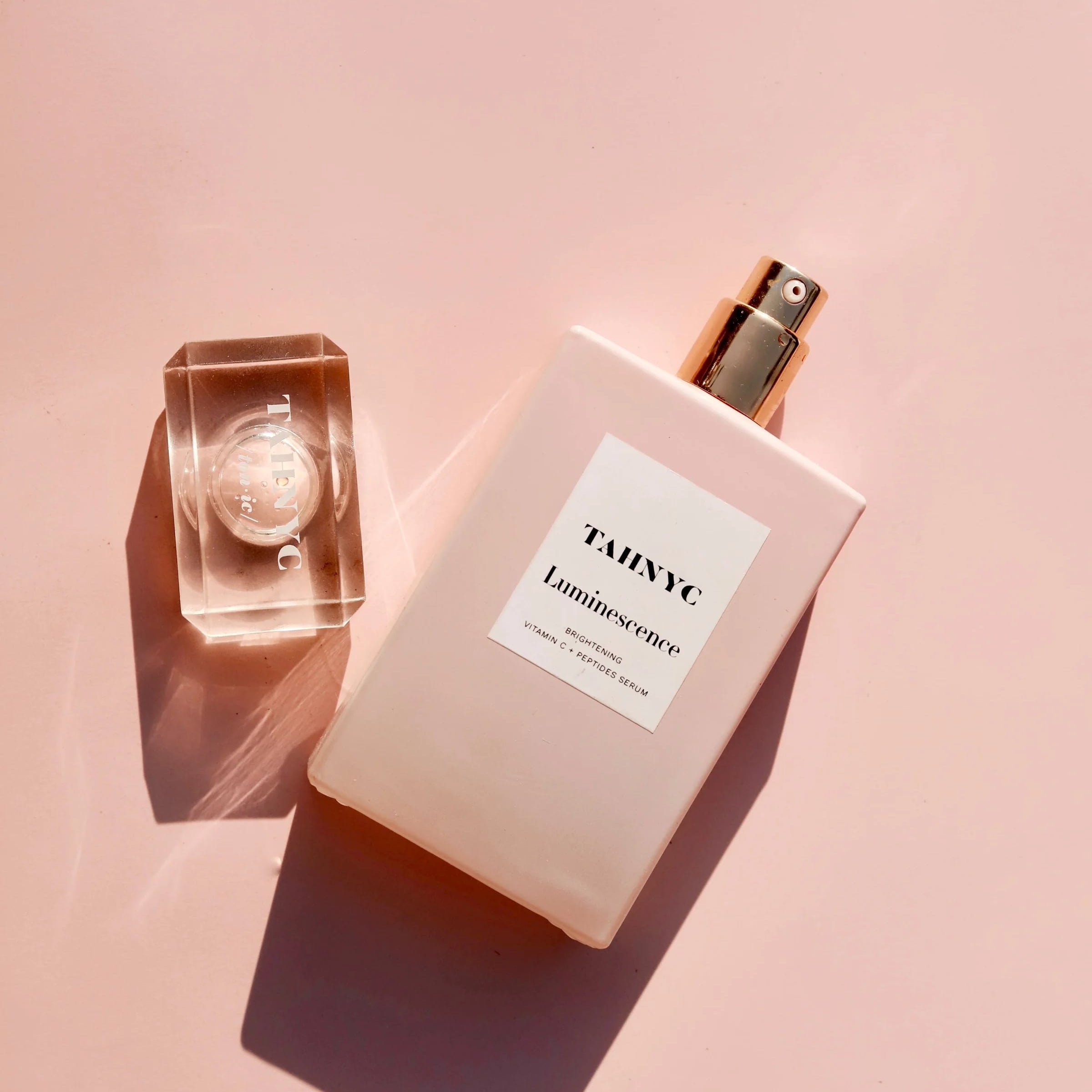 TAHNYC Luminescence Vitamin C + Peptides Serum flatlay with crystal cap and soft blush background – The Pharmacy Lab