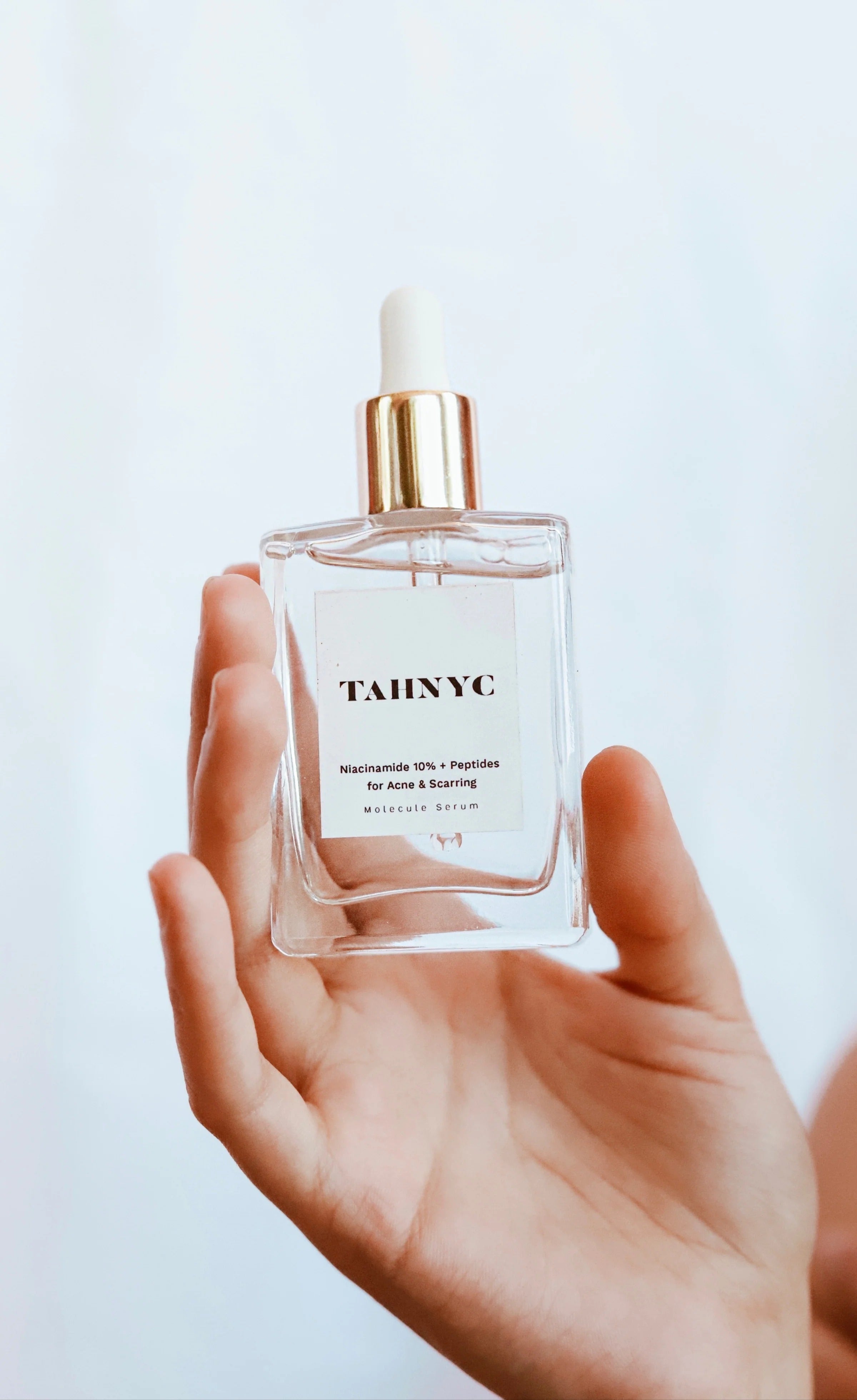 TAHNYC Niacinamide 10% + Peptides acne serum held in hand against soft white background – The Pharmacy Lab