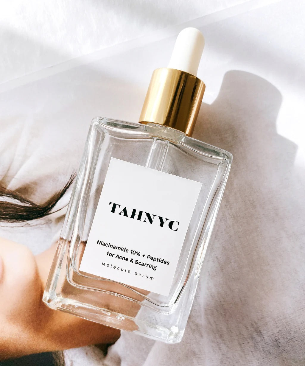 TAHNYC Niacinamide 10% + Peptides serum flatlay over editorial image with soft daylight – The Pharmacy Lab
