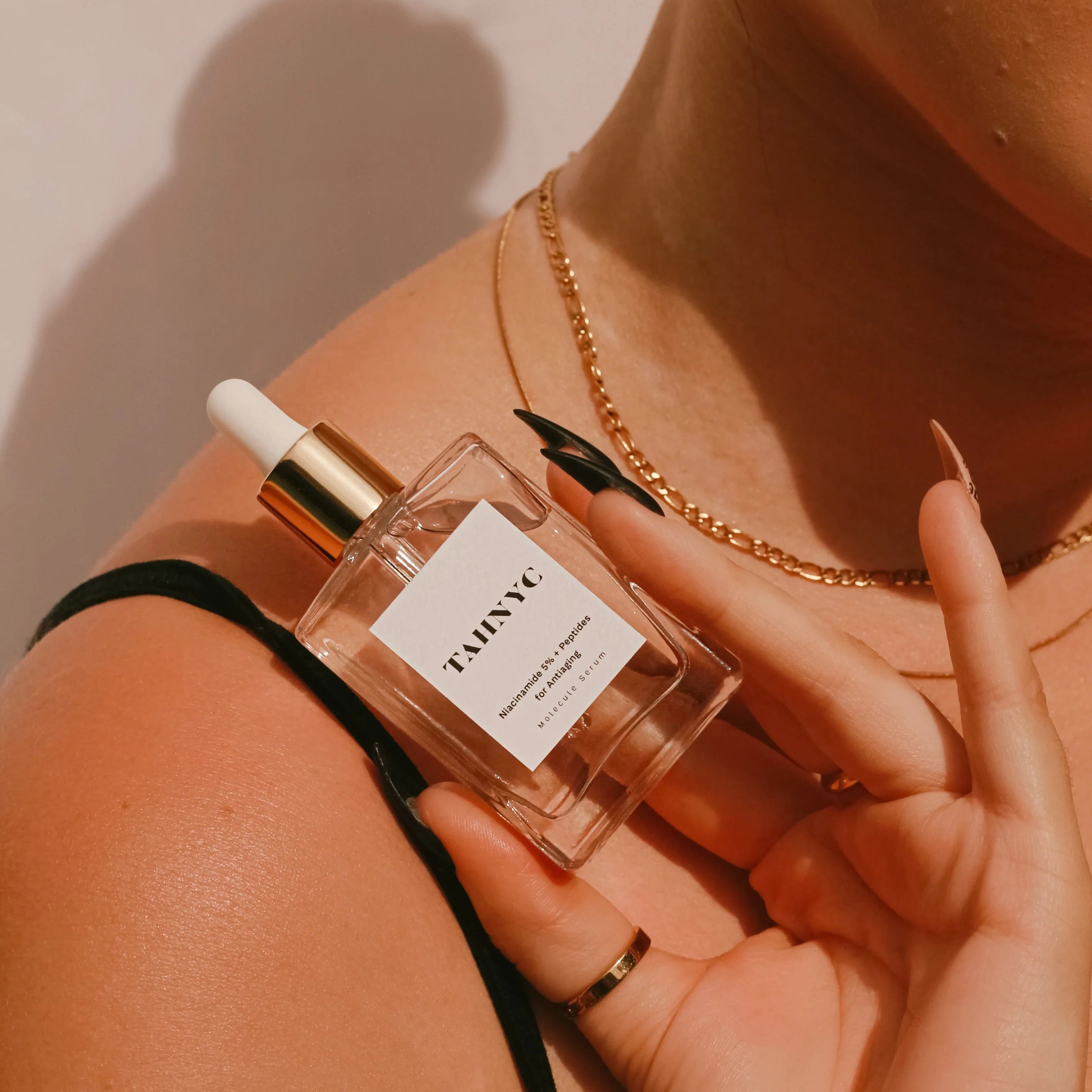 Model applying TAHNYC Niacinamide 5% + Peptides Serum dropper to face – The Pharmacy Lab