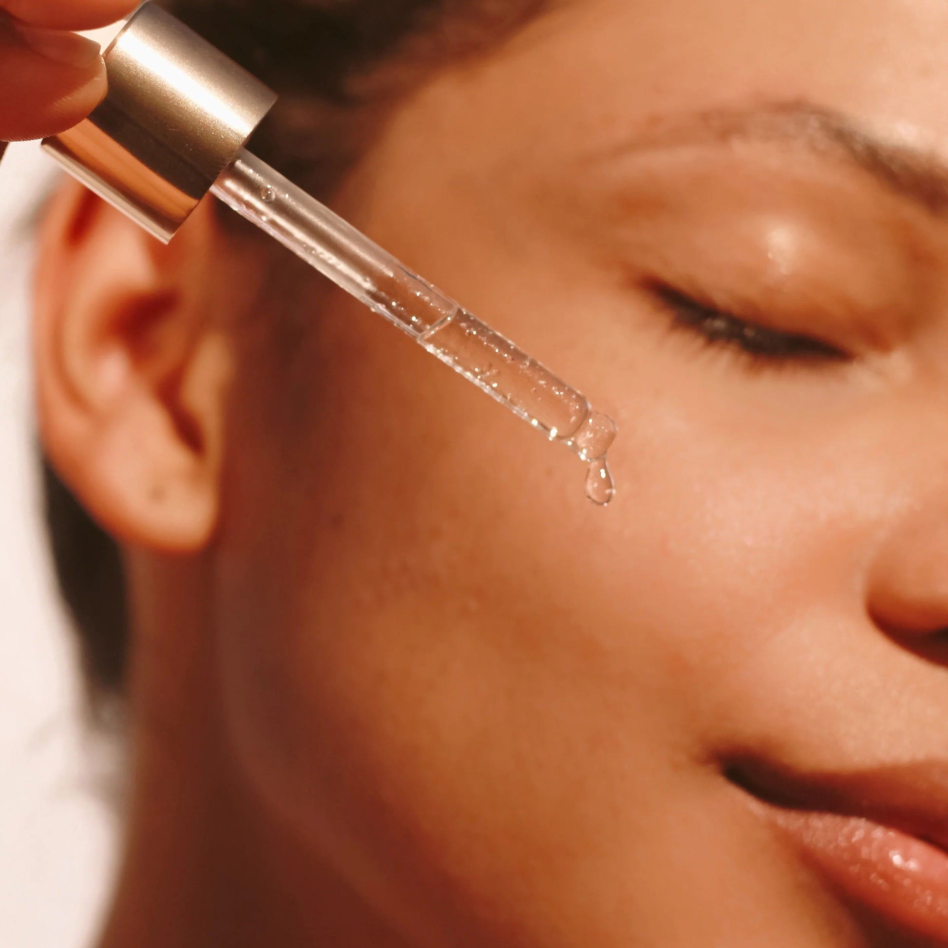 Model holding TAHNYC Niacinamide 5% + Peptides Serum bottle against skin – The Pharmacy Lab