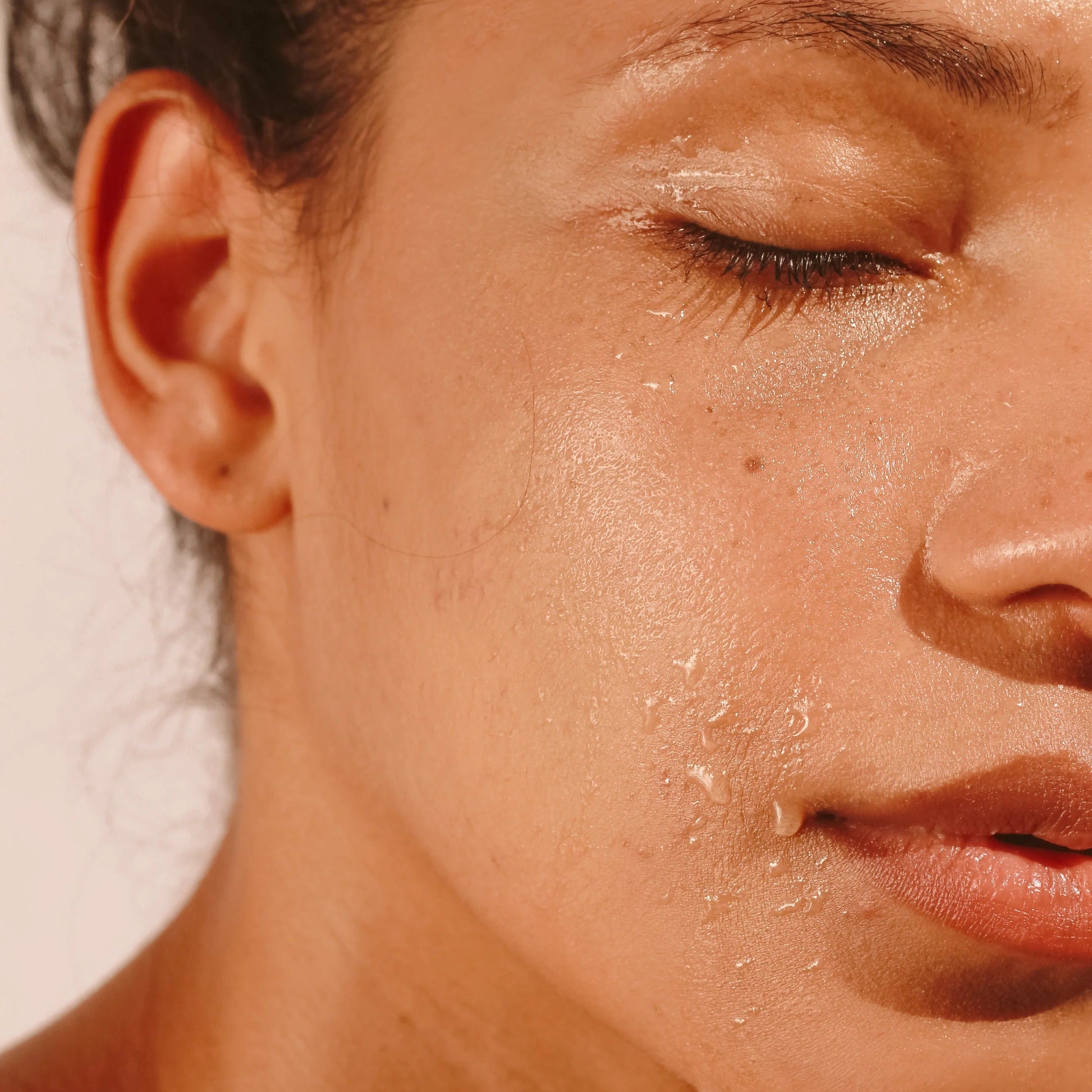 Close-up of model’s glowing skin with TAHNYC serum applied – The Pharmacy Lab