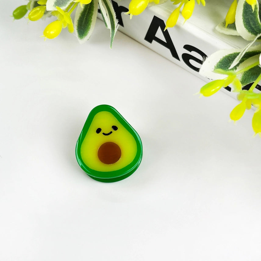 Avocado-shaped object with a face on a white background with yellow flowers
