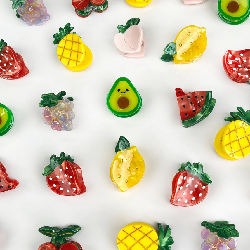 Colorful fruit-shaped hair clips on a white background
