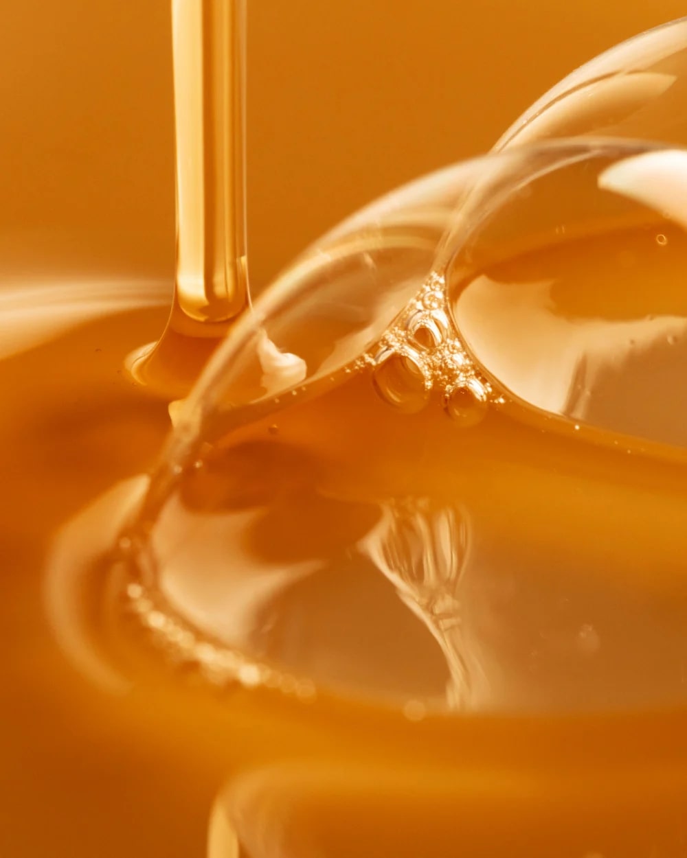 Close-up of honey being drizzled into a bowl with a blurred background
