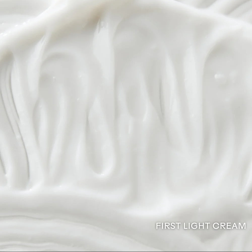 Close-up of smooth, light cream-colored fabric texture with 'First Light Cream' label.