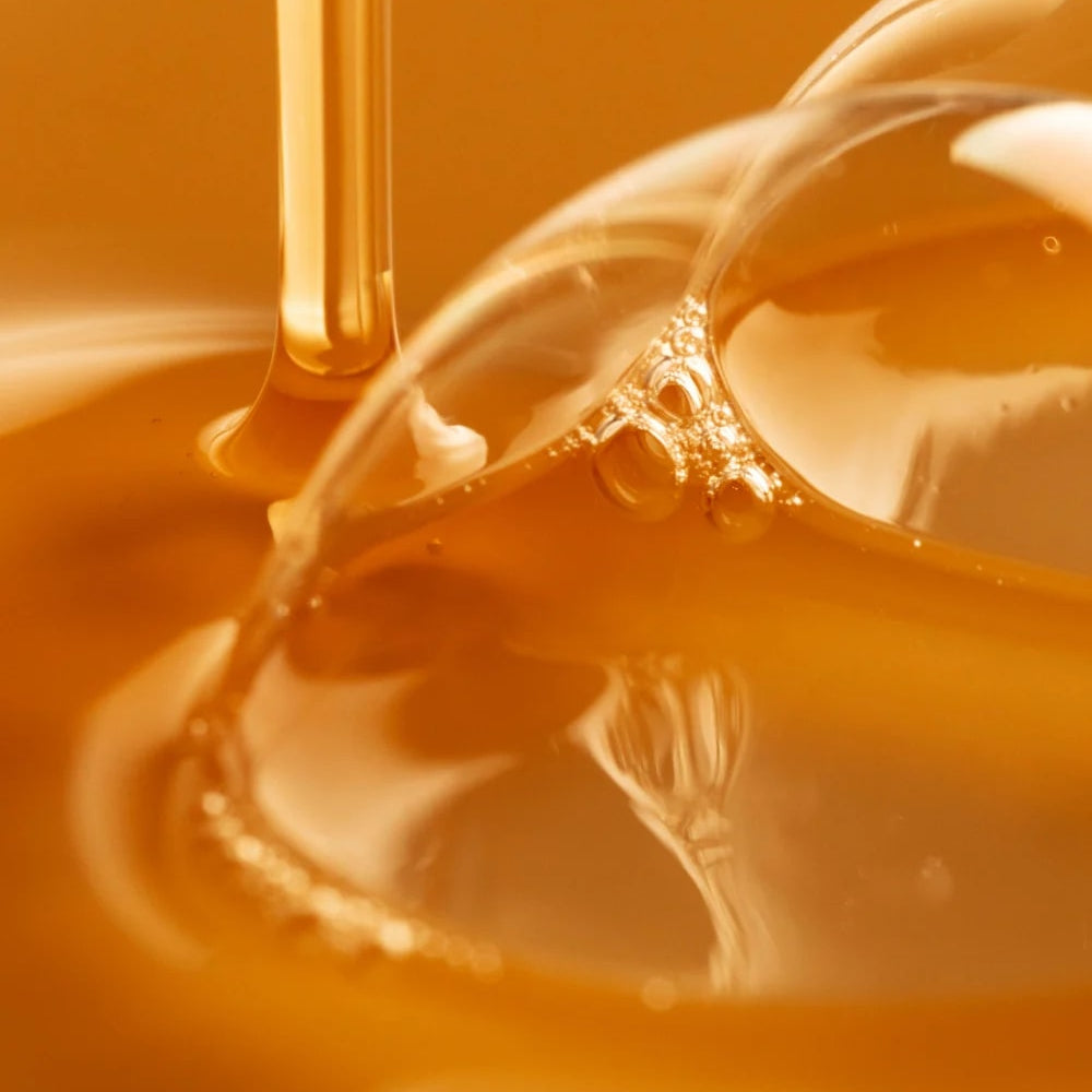 Close-up of honey being drizzled into a bowl with a blurred background