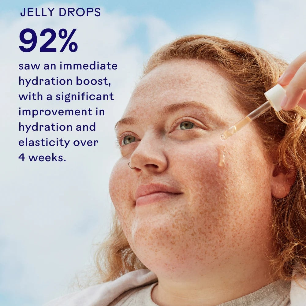 Woman applying jelly drops to her face with a blue sky background