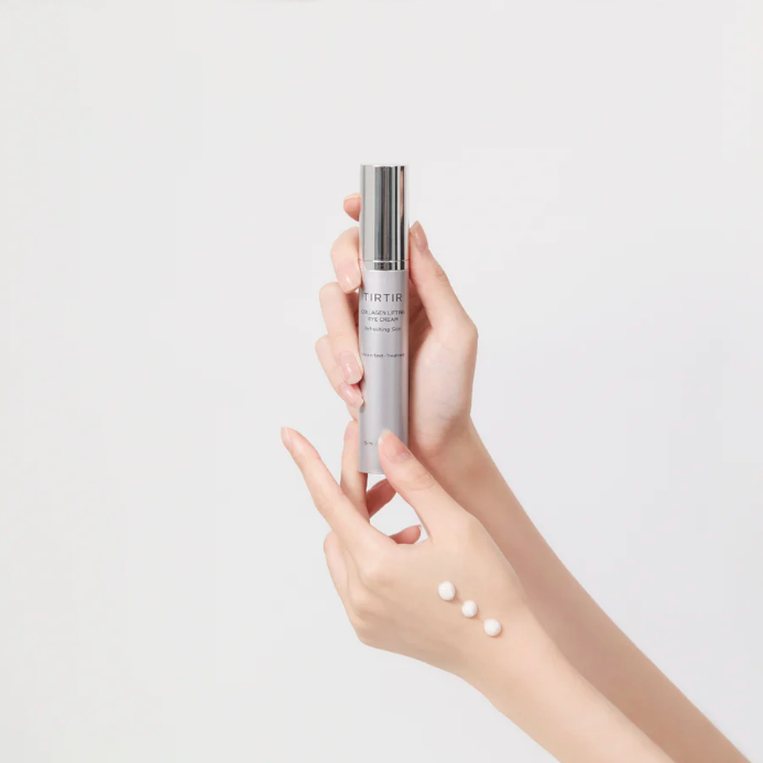 Hand holding a skincare product with a plain background