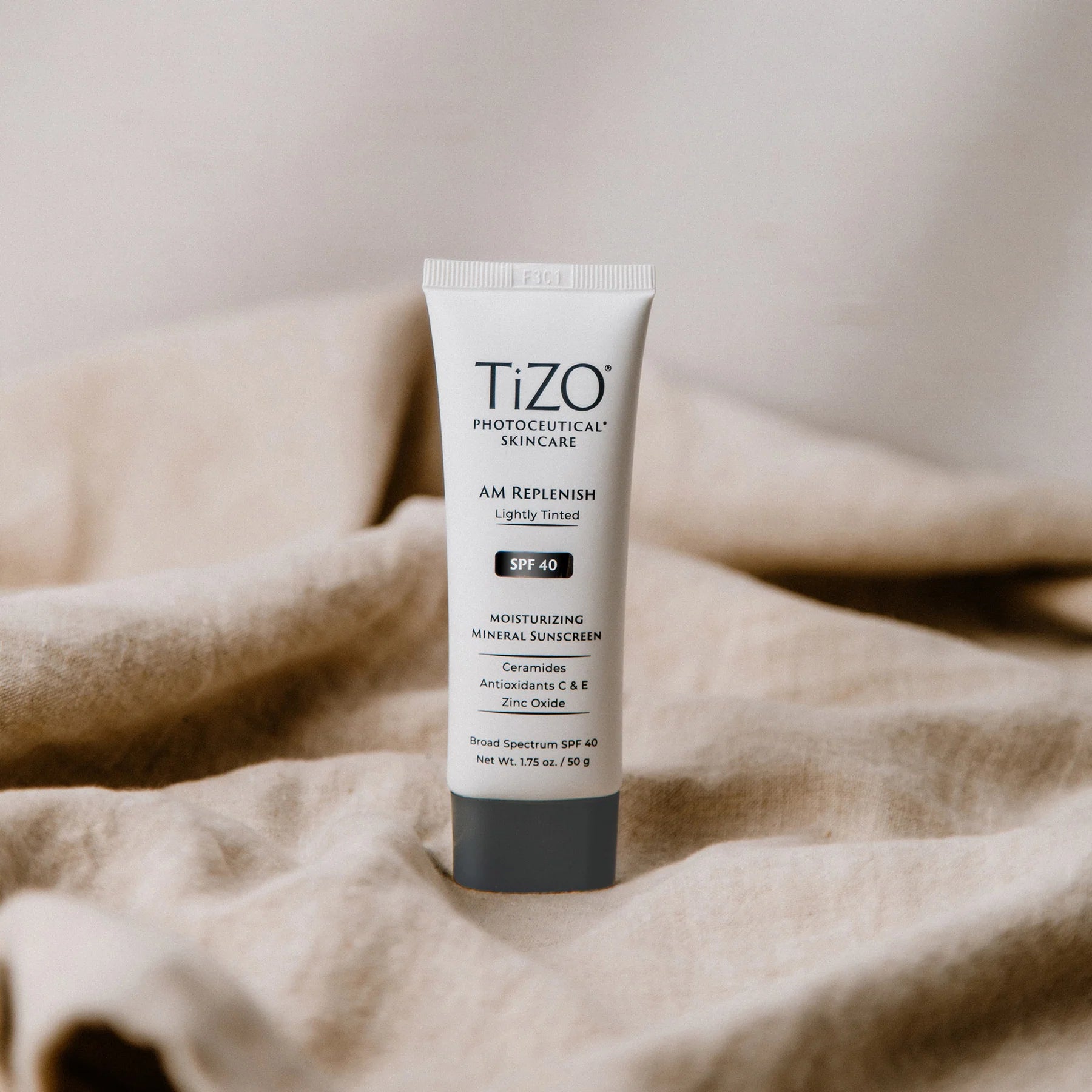 Tizo skincare tube on a beige fabric background