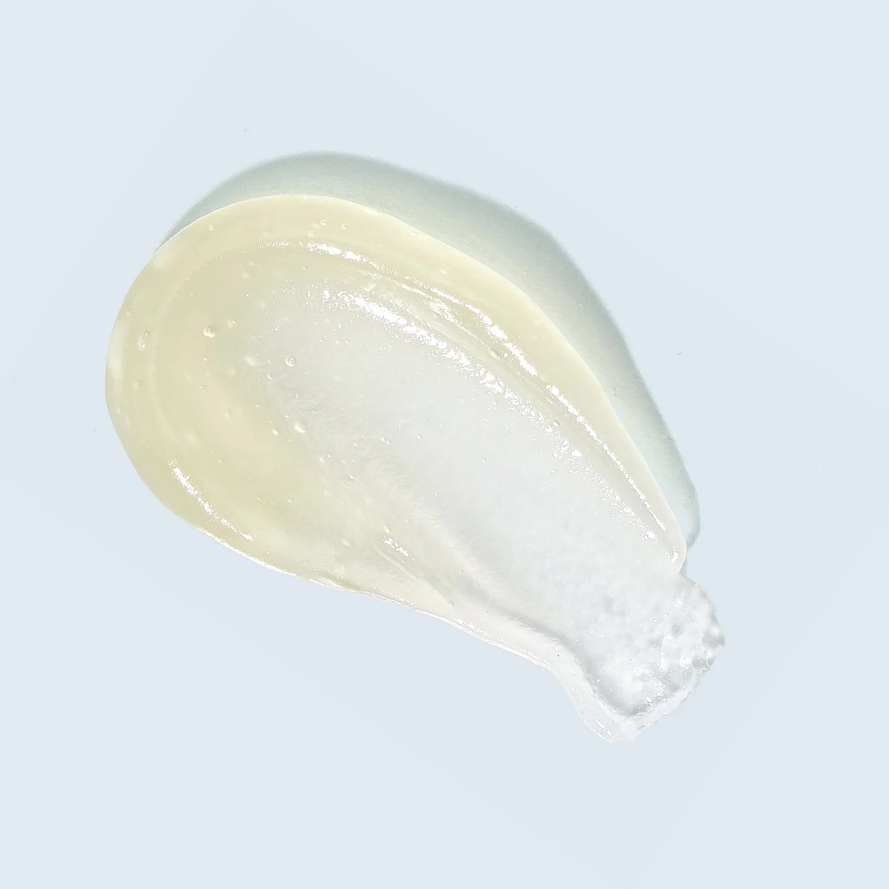 White cream or paste on a light gray background