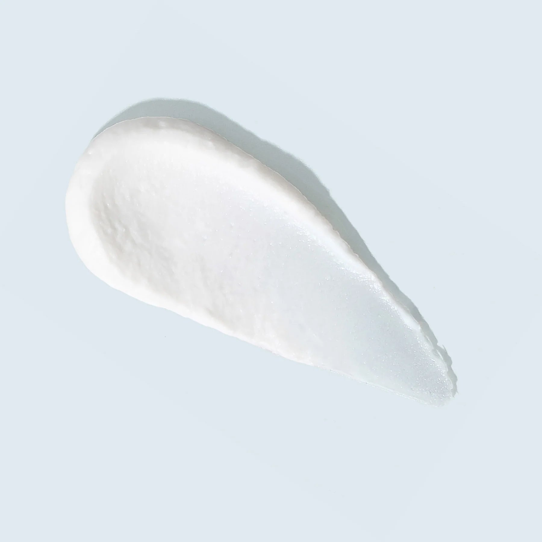 White cream or lotion swatch on a light gray background