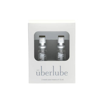 Two travel case inserts of überlube in a clear window box on a white background
