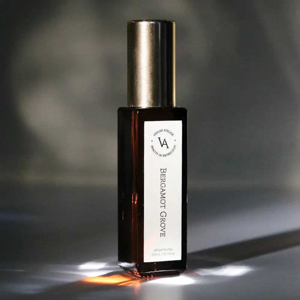 Bottle of Bergamot Grove essential oil with a metallic cap on a dark background