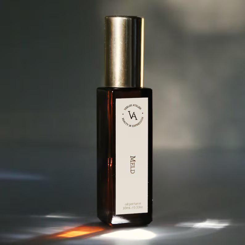 Perfume bottle with gold cap and white label on a dark background