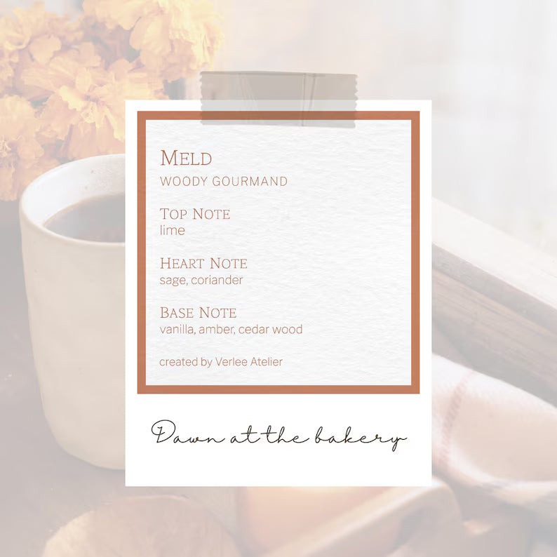 Candle with a label detailing its fragrance profile, set against a blurred background of flowers and a cup.