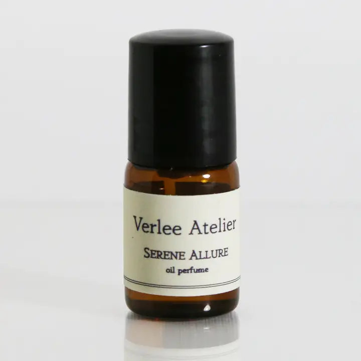 Small amber glass bottle with a black cap labeled 'Verlee Atelier Serene Allure' on a white background