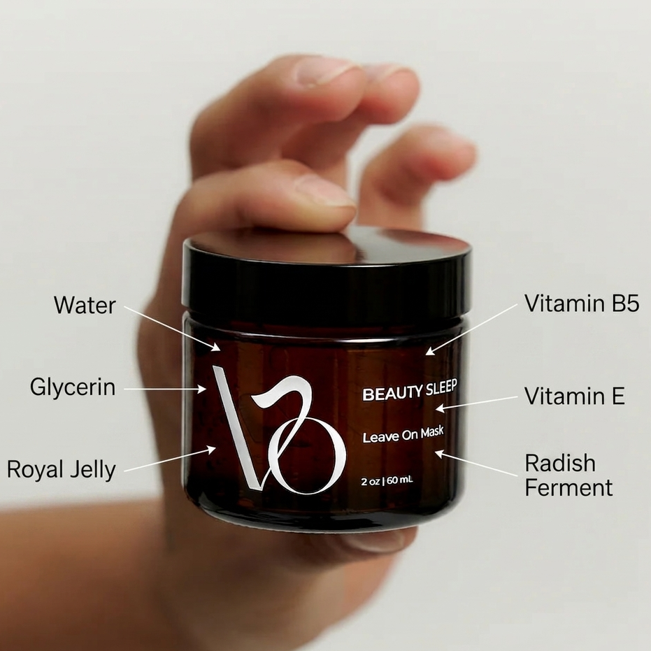 Hand holding a jar of 'Beauty Sleep' leave-on mask with ingredient labels on a light gray background