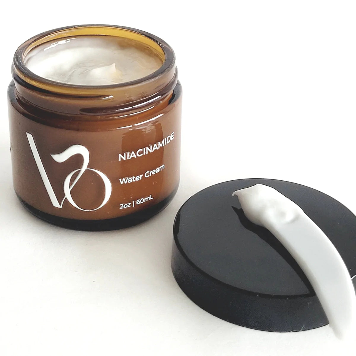 Brown jar of V3 Niacinamide Water Cream with a black lid and white applicator on a white background