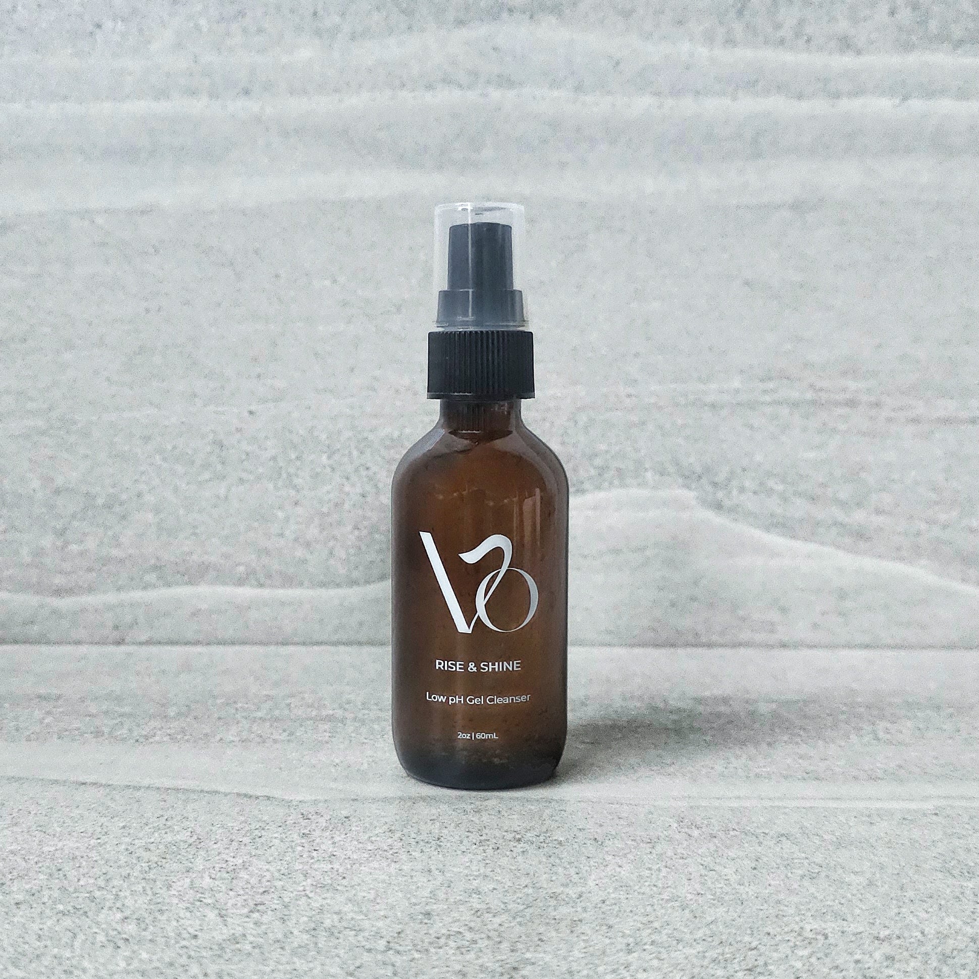 Brown spray bottle with 'VO' logo on a textured gray background