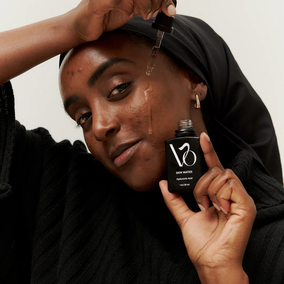 Model applying VO Beauty Skin Water 2% Hyaluronic Acid Serum – lightweight hydrating serum for sensitive and acne-prone skin.